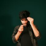 Young man examining his hairline for signs of hair loss or hair thinning, showcasing personal grooming and care