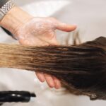 Close-up of a professional hair wash in a salon setting, highlighting hand technique