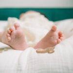 Adorable baby feet resting on a plush, patterned blanket indoors