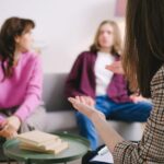 Engaged counseling session with three adults discussing together in a cozy indoor setting