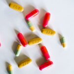 A vibrant assortment of colorful capsules and pills scattered on a white surface