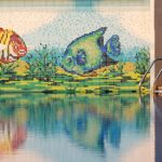 Colorful mosaic fish decor with pool reflection, perfect for summer vibes