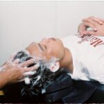 A person enjoying a soothing hair wash in a salon setting, conveying relaxation
