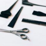 A collection of essential hairdressing tools including scissors and combs on a white surface