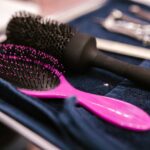 Close-up of pink and black hairbrushes on a towel in a salon setting