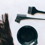 Top view of hair coloring tools and hair strands on a white background