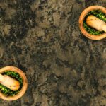 Aerial view of wooden mortars and pestles filled with fresh green pesto