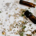 Aromatherapy setup with essential oil bottles and dried herbs on a white surface for holistic healing